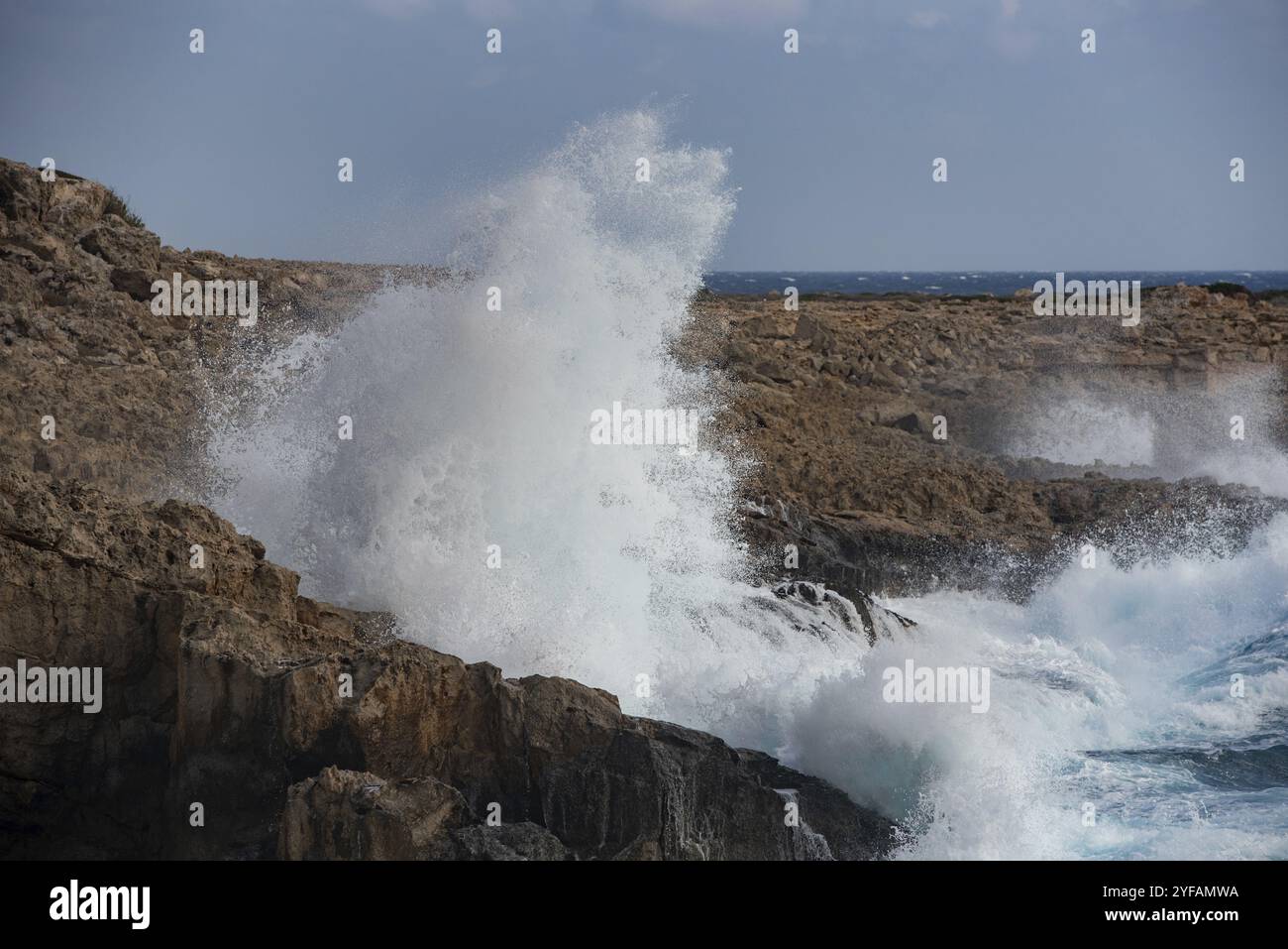 Windige Meereswellen, die vor Energie an der felsigen Küste zusammenbrechen. Naturkraft Wind stürmischer Tag Stockfoto