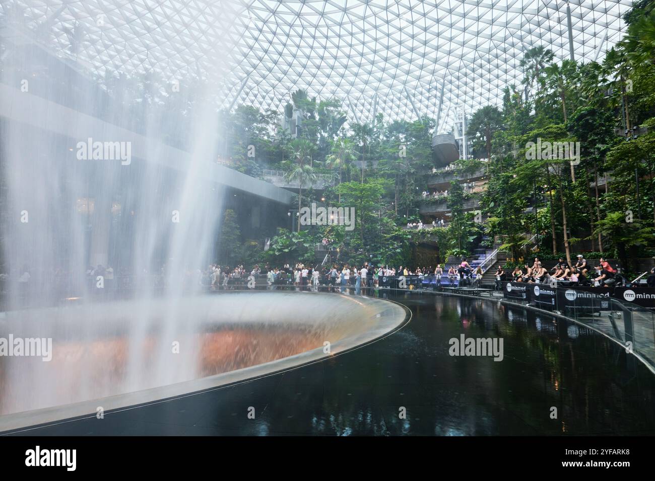 Singapur - 12. August 2024: Tropischer Indoor-Garten und Wasserfall im Einkaufszentrum Jewel am Flughafen Changi, entworfen von Safdie Architects Stockfoto