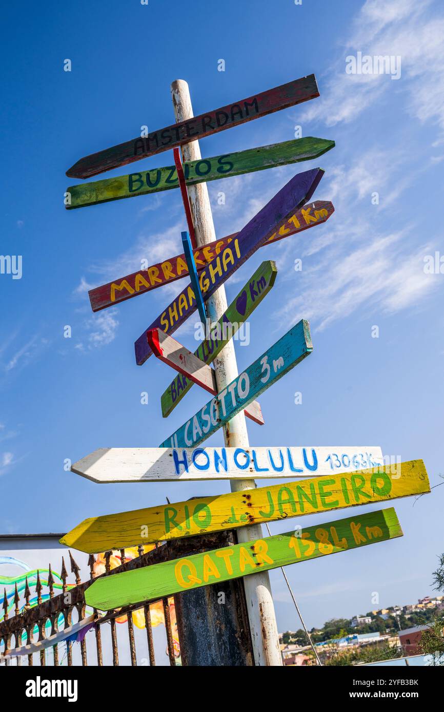 Farbenfrohes hölzernes Schild mit den Namen internationaler Reiseziele und Entfernungen, Procida, Kampanien, Italien Stockfoto