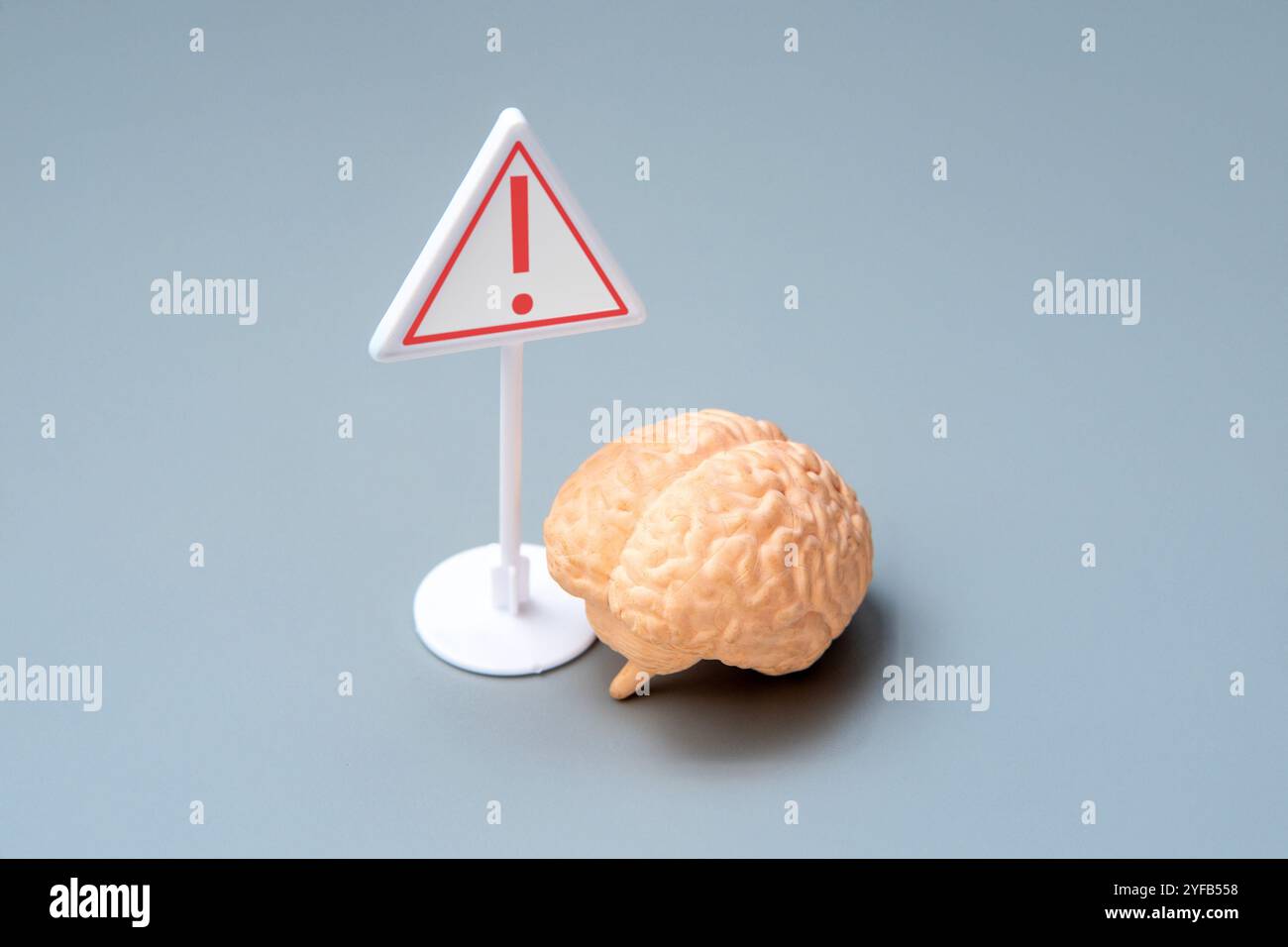 Ein Hirnmodell mit Warnzeichen. Hirngesundheit und das Risikopotenzial-Konzept. Stockfoto