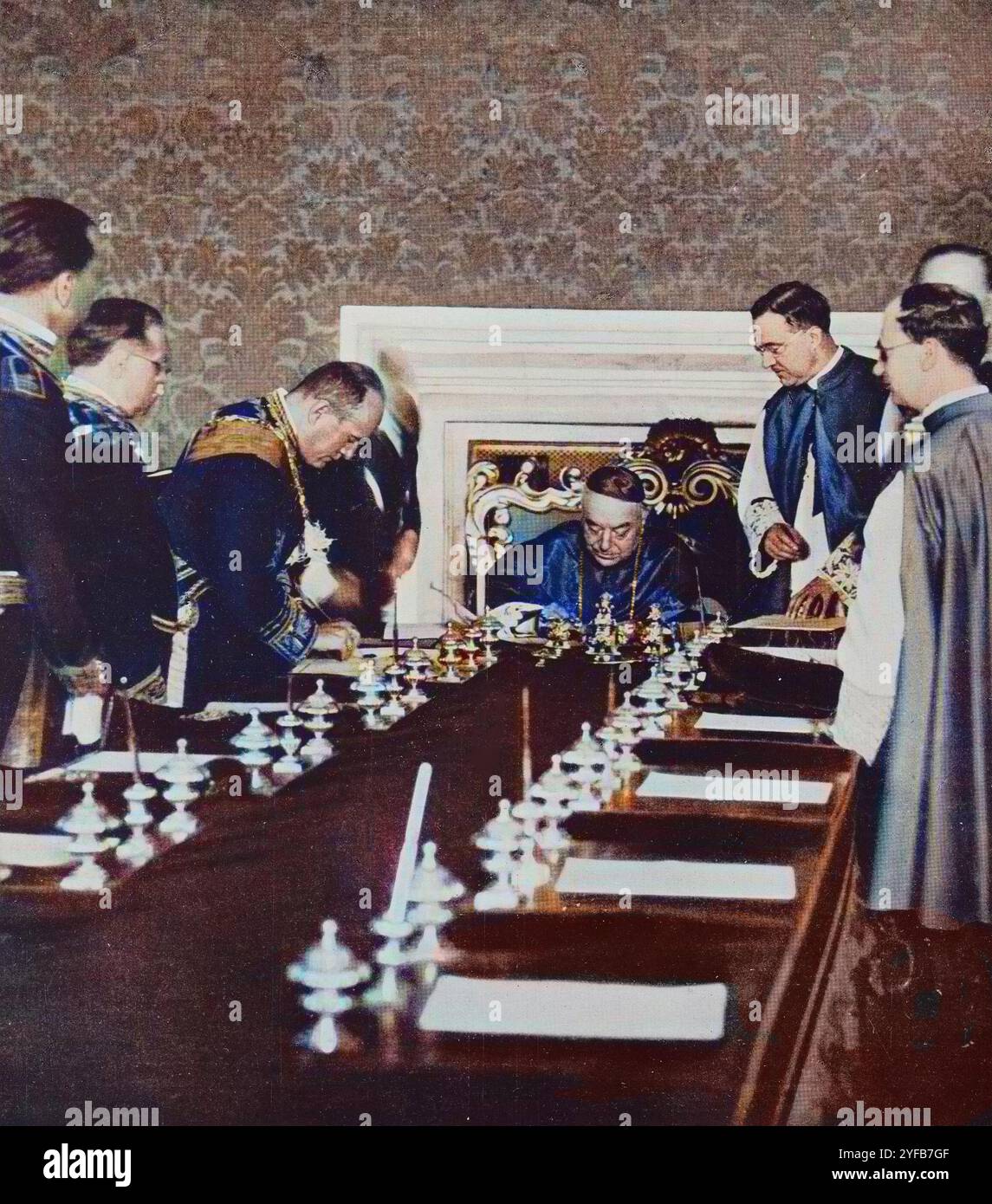 Benito Mussolini und Kardinal Pietro Gasparri unterzeichnen die Ratifizierung der Lateranpakte im Saal der Versammlungen des Vatikans, 7. Juni 1929 - spätere Färbung. Stockfoto