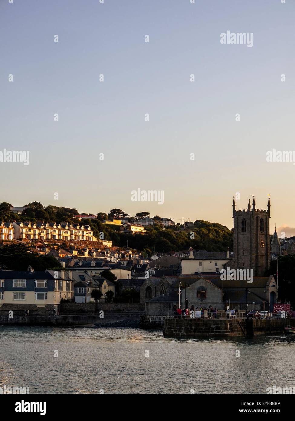 Sonnenlicht von Sonnenuntergang trifft Häuser, und die Uhr der St IAS Parish Church, St Ives, Cornwall, England, Großbritannien, GB Stockfoto