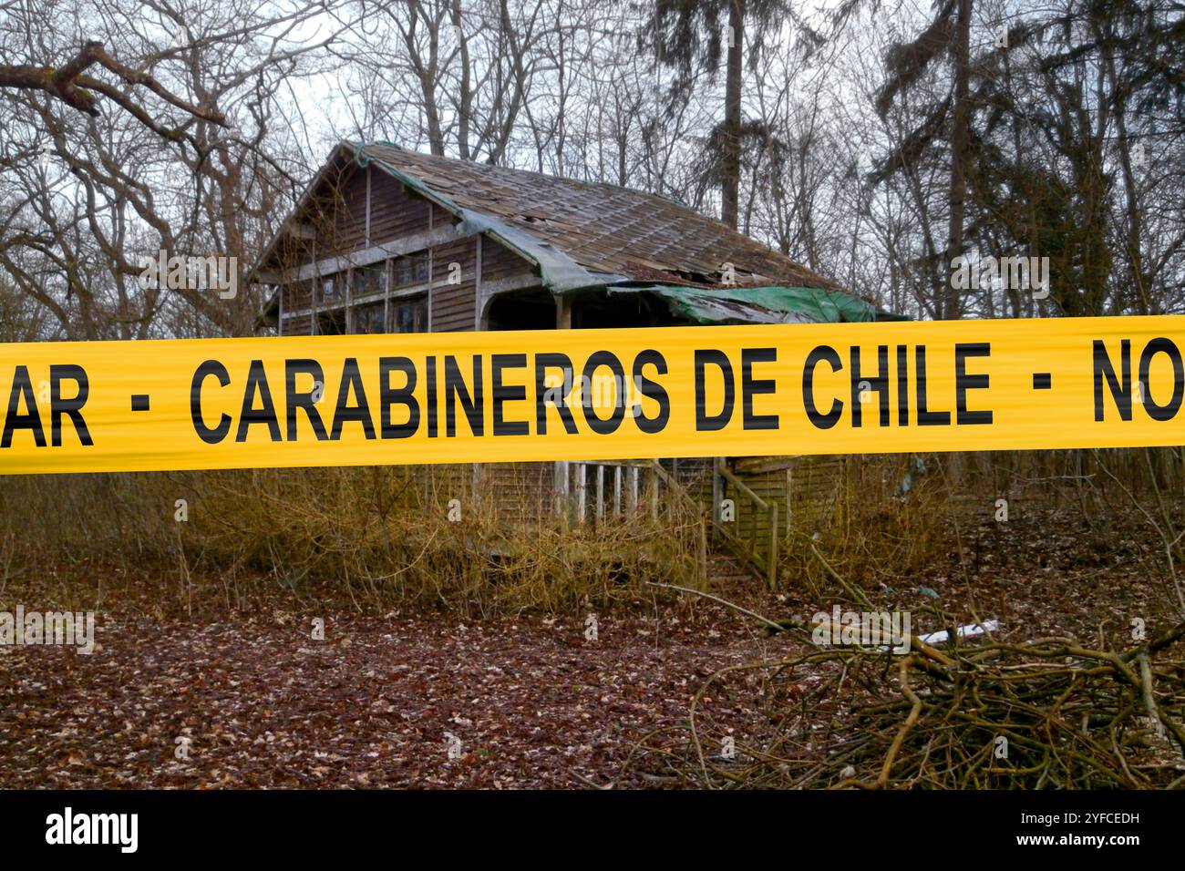 Verlassene Hütte im Wald mit einem Polizeiband, auf dem auf Spanisch geschrieben steht: „Carabineros de Chile - No Pasar“, was auf Englisch „Carabiniers of Chi“ bedeutet Stockfoto