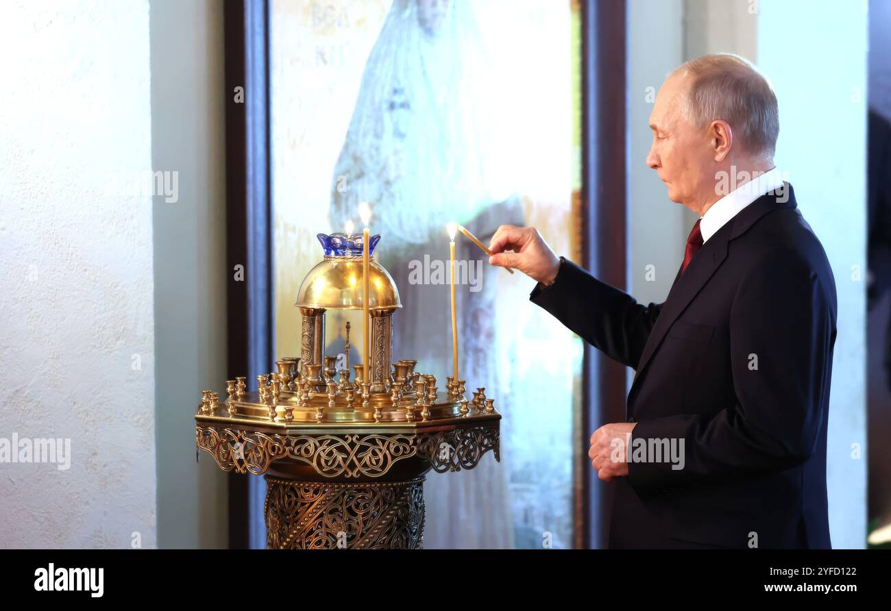 Moskau, Russland. November 2024. Der russische Präsident Wladimir Putin zündet eine Kerze während eines Besuchs des Orthodoxen Russland-Ausstellungsforums am Tag der Nationalen Einheit in der zentralen Ausstellungshalle von Manezh am 4. November 2024 in Moskau, Russland Credit: Vyacheslav Prokofyev/Kreml Pool/Alamy Live News Stockfoto