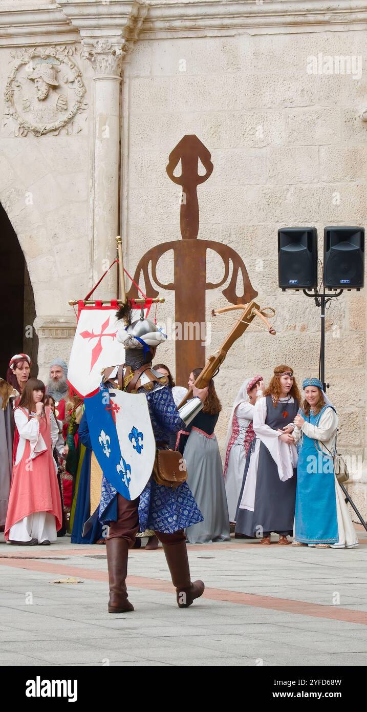 Die Teilnehmer der El-Cid-Partys ziehen mit einem Ritter in Rüstung vor dem Stadttor von St. Marienbogen Burgos Castile und Leon Spanien Stockfoto