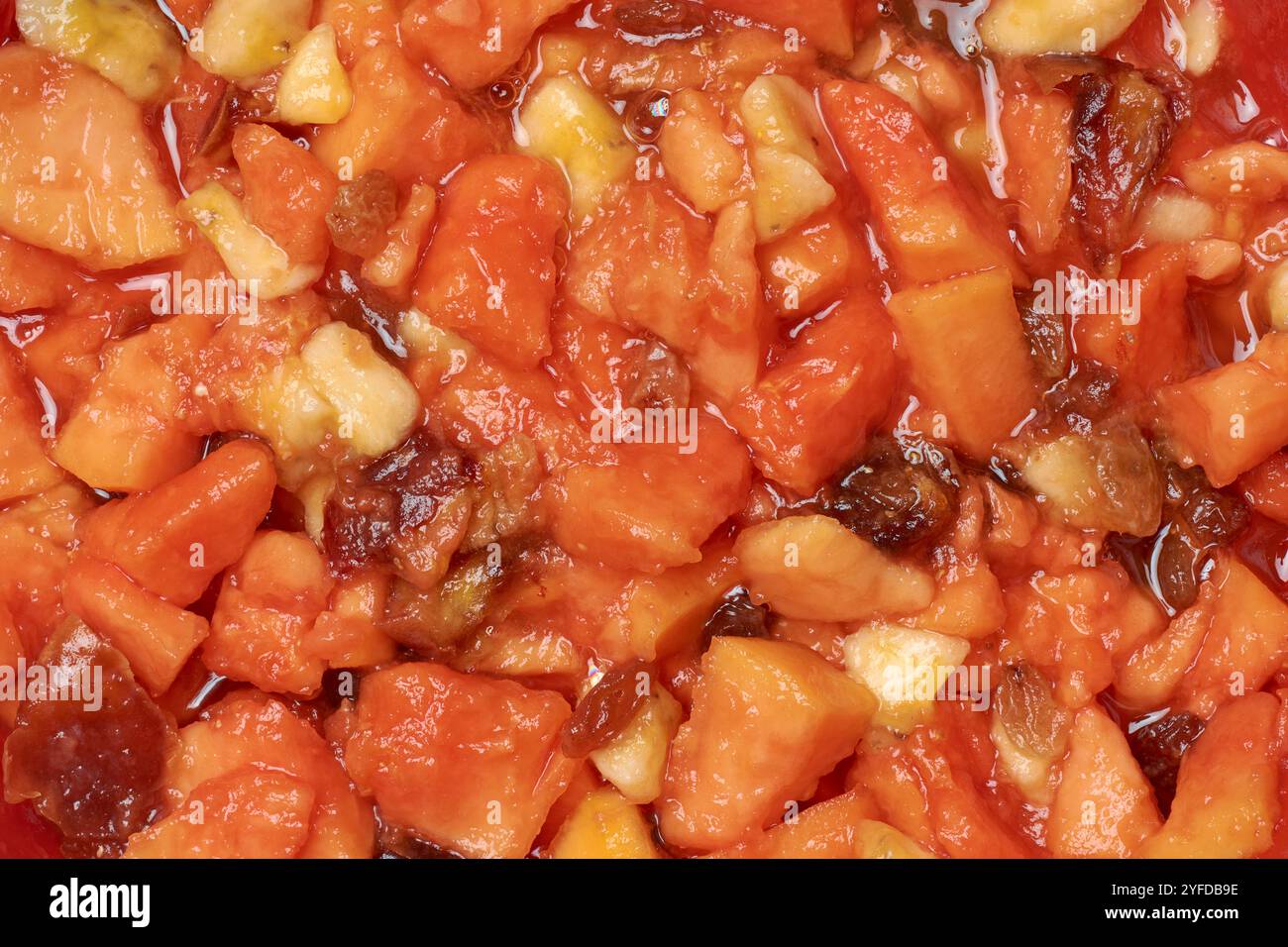 Gemischte Fruchtsalate aus gehackter Papaya, Banane, Pflaumen und Datteln, köstliches, nährstoffreiches Dessert im Vollformat Stockfoto