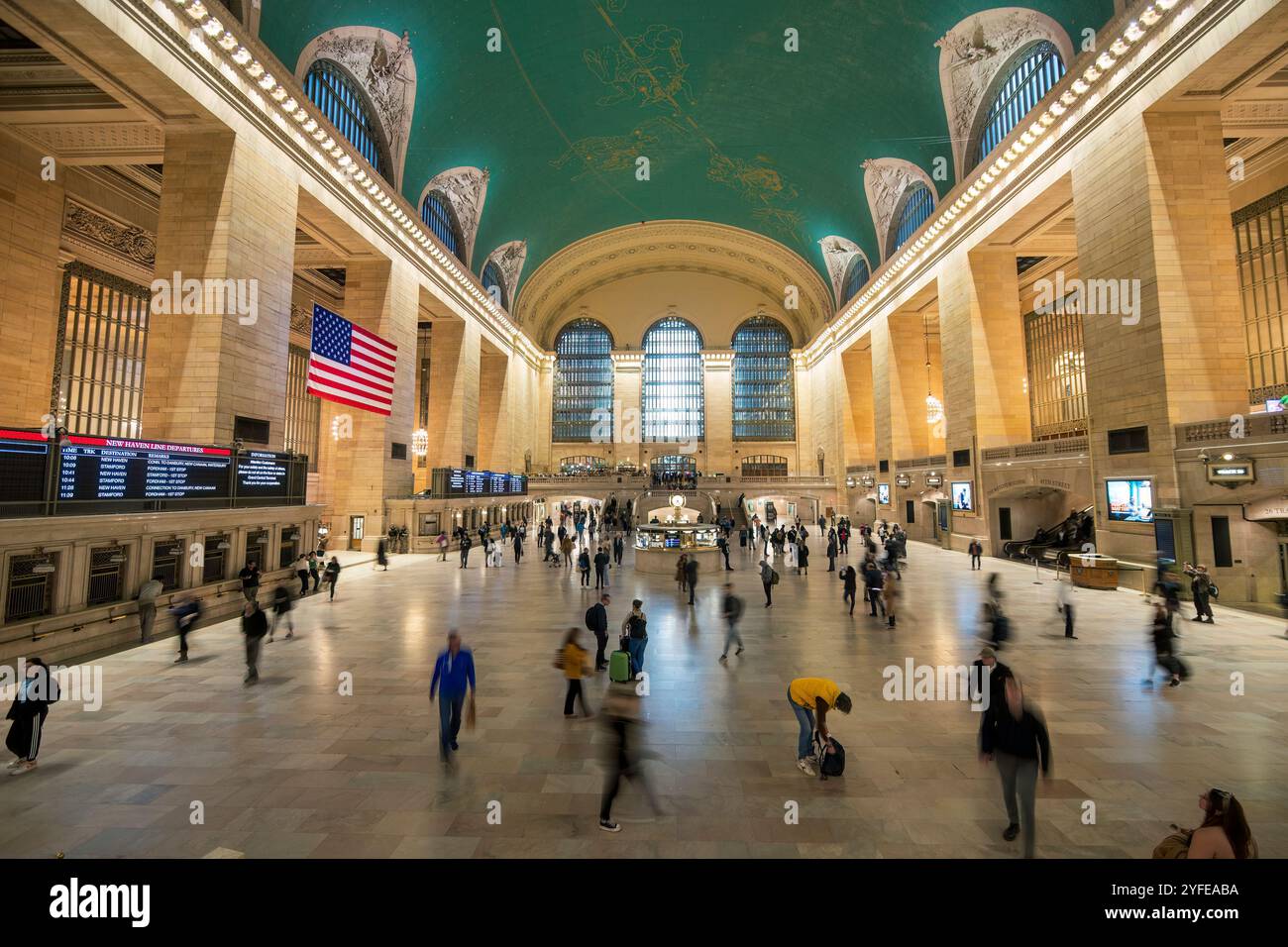 Großer Blick auf die Haupthalle des Grand Central Terminals in New York City, die Menschen in Bewegung unter der berühmten himmlischen Decke zeigt. Stockfoto