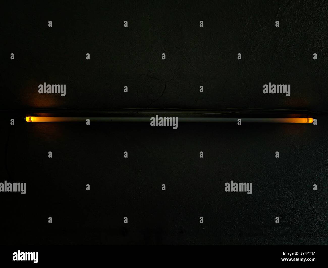 Flackerndes Neonlicht an der Decke mit orangefarbenen Kanten – Dark Space Ambiance Stockfoto