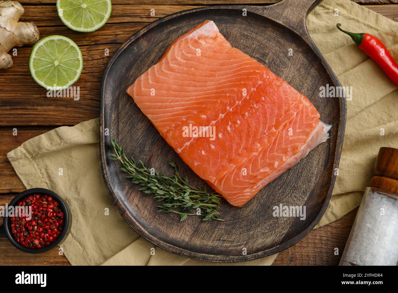 Lachsfilet, Gewürze und Limette auf Holztisch, flache Ladefläche Stockfoto