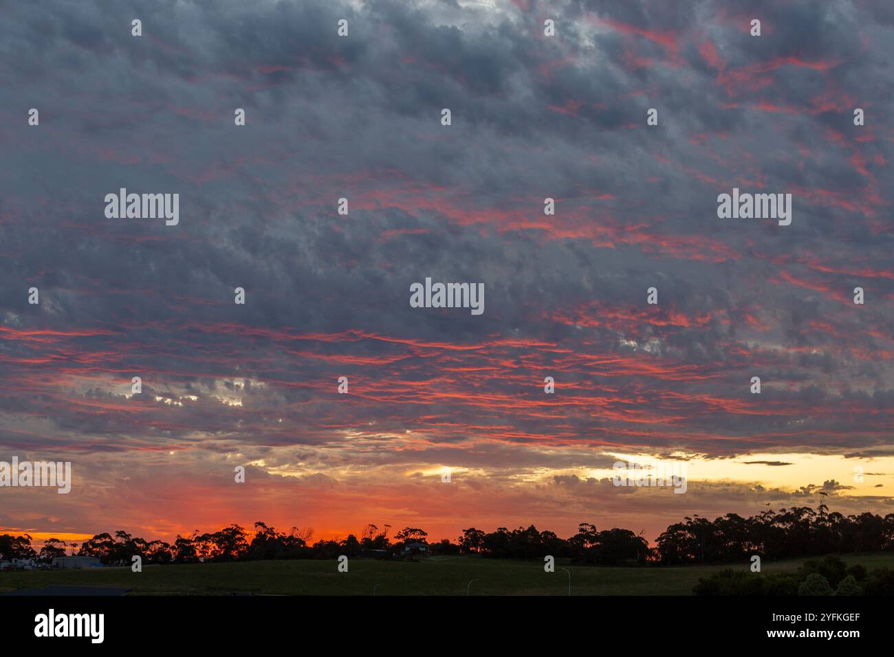 Dramatischer Sonnenuntergangshimmel mit Wolkenschichten und blauen und rosa Highlights über Wolken. Stockfoto