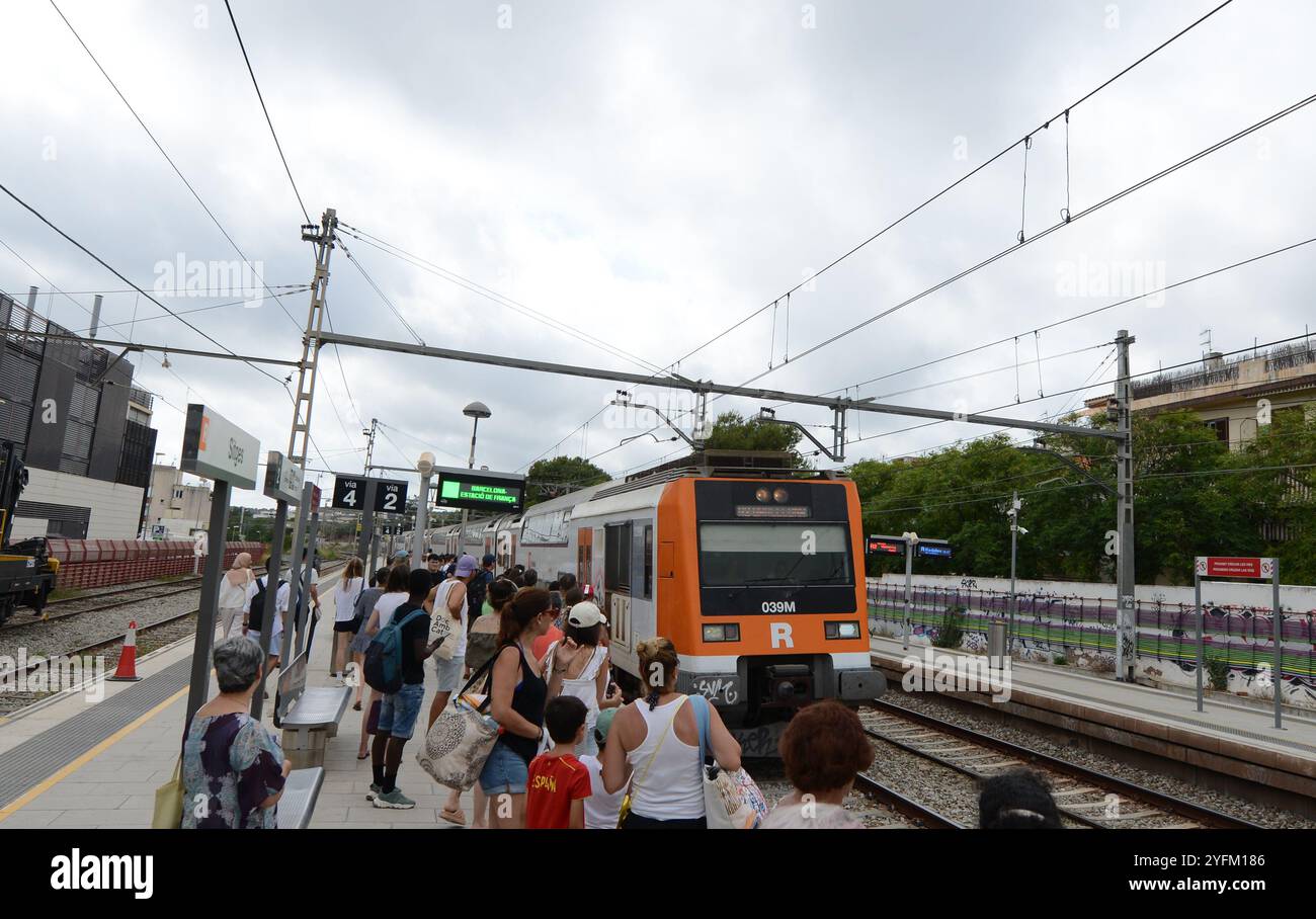 Passagiere, die am Bahnsteig in Sitges, Katalonien, Spanien auf den Zug warten. Stockfoto