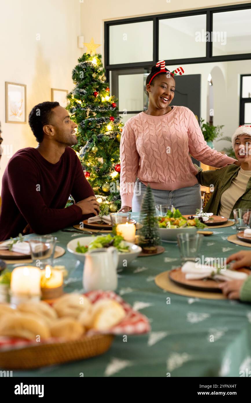 Weihnachten, afroamerikanerin lacht mit multirassischen Freunden, zu Hause Stockfoto