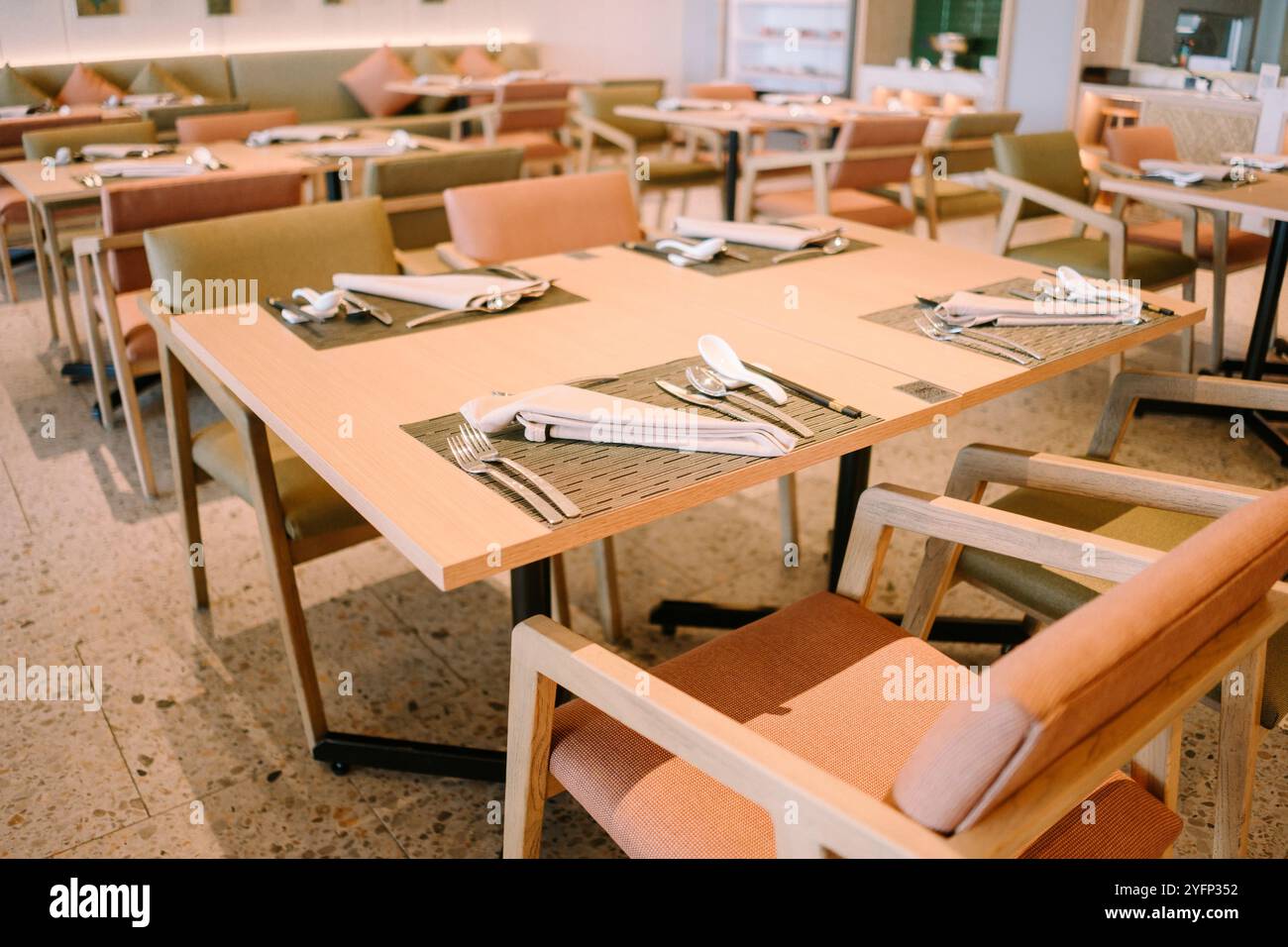 Elegantes Interieur des Hotelrestaurants mit ordentlich angeordneten Tischen, warmer Beleuchtung und raffinierter Einrichtung, die einen einladenden und komfortablen geldautomat schaffen Stockfoto