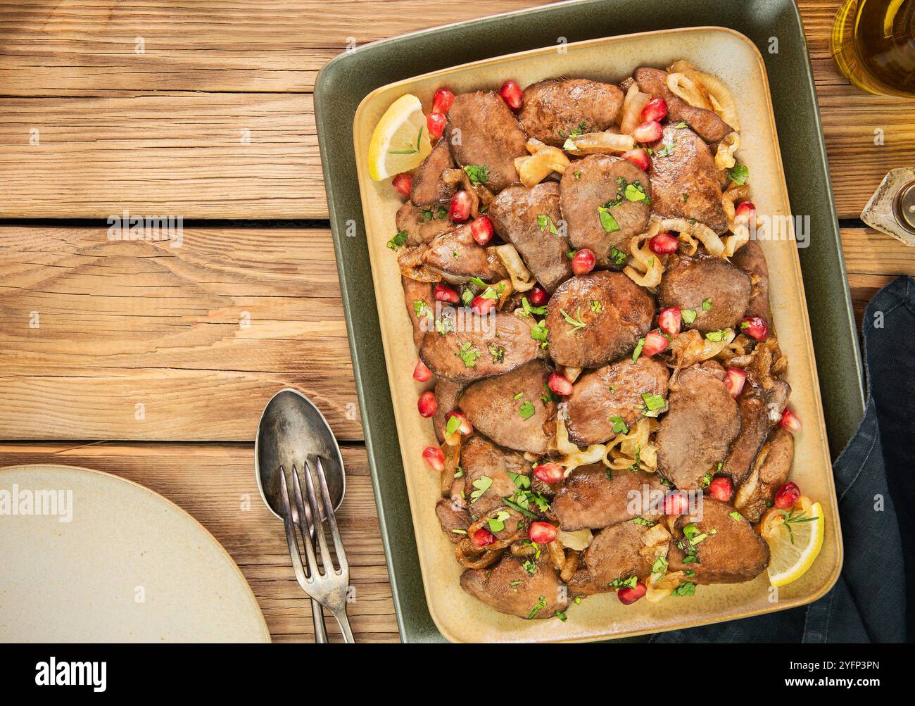 Arabische Küche; zarte Hühnerleber mit ZitronenKnoblauch und karamelisierten Zwiebeln. In einer süßen, würzigen Granatapfelglasur gekocht. Garniert mit Granatapfelkernen Stockfoto
