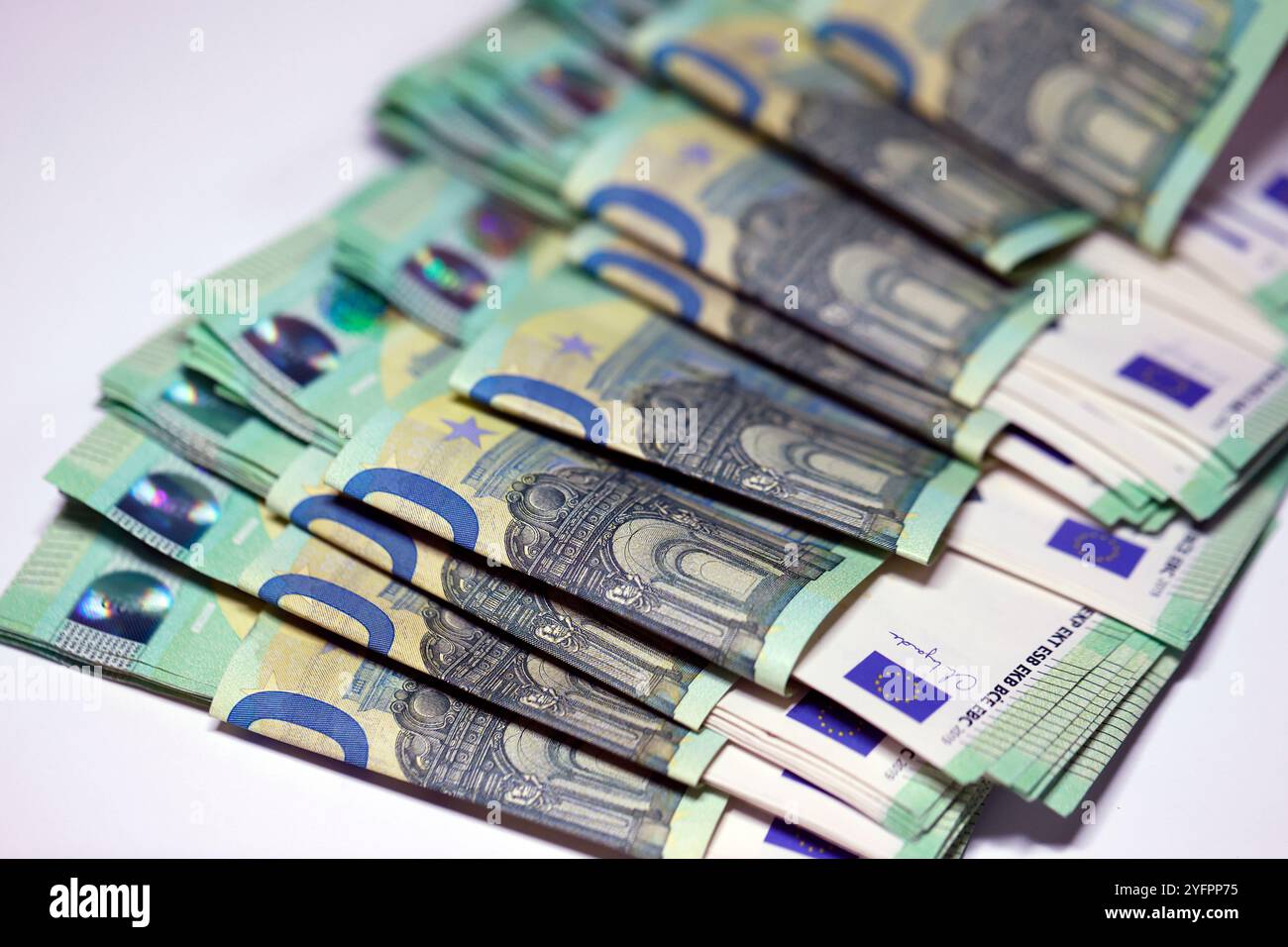 100 Euro-Banknoten, die auf dem Tisch verteilt sind und Steuern zahlen Inflation in Europa. Stockfoto