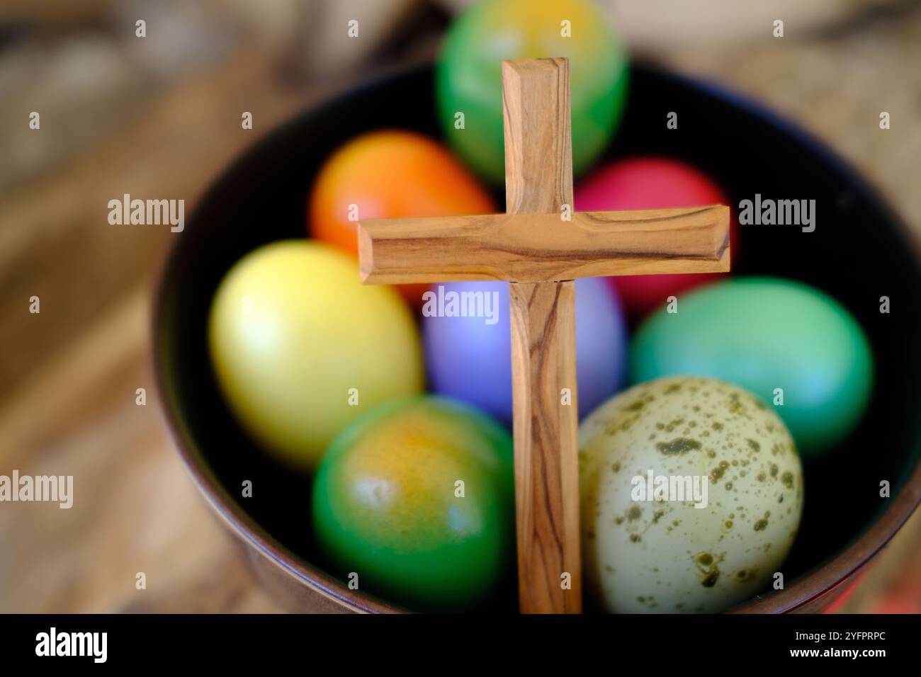 Frohe Ostern. Ostereier mit einem Holzkreuz. Die Auferstehung Christi ist der älteste und christlichste Feiertag. Stockfoto