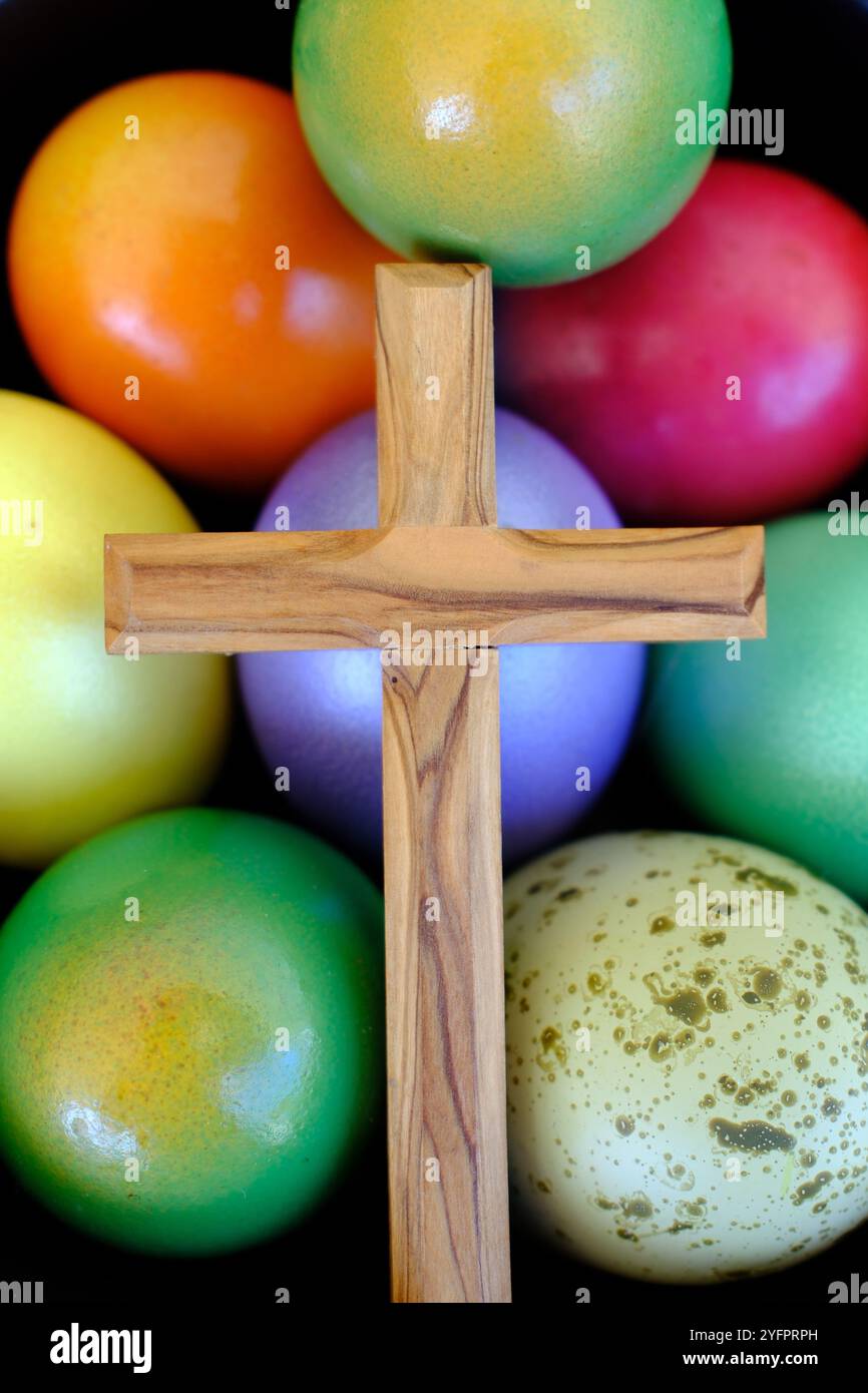 Frohe Ostern. Ostereier mit einem Holzkreuz. Die Auferstehung Christi ist der älteste und christlichste Feiertag. Stockfoto