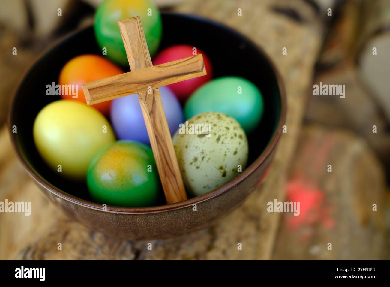 Frohe Ostern. Ostereier mit einem Holzkreuz. Die Auferstehung Christi ist der älteste und christlichste Feiertag. Stockfoto