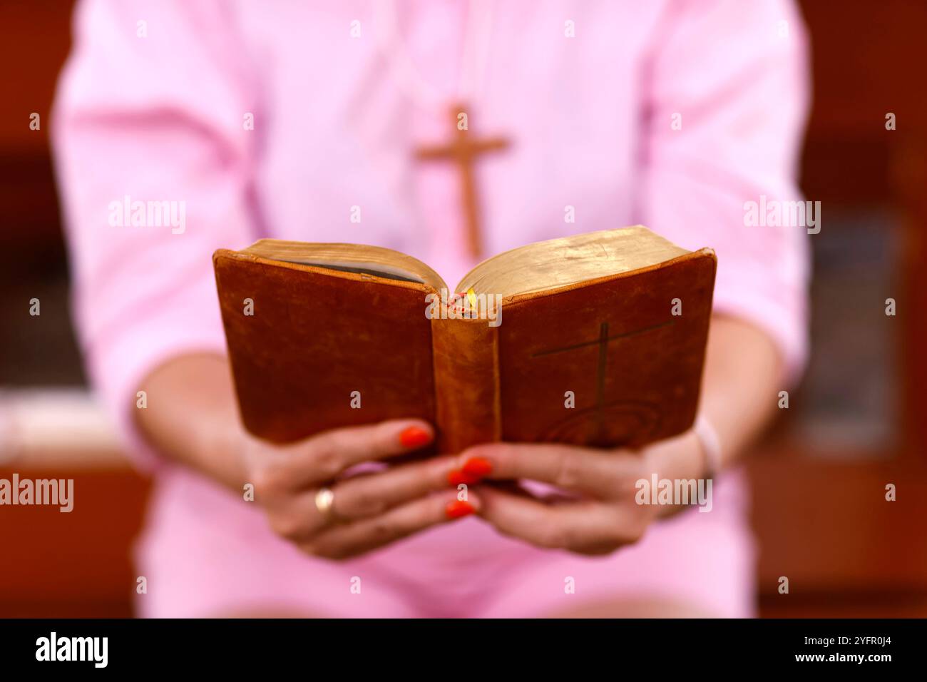 Eine Frau liest eine alte Bibel in einer Kirche. Stockfoto