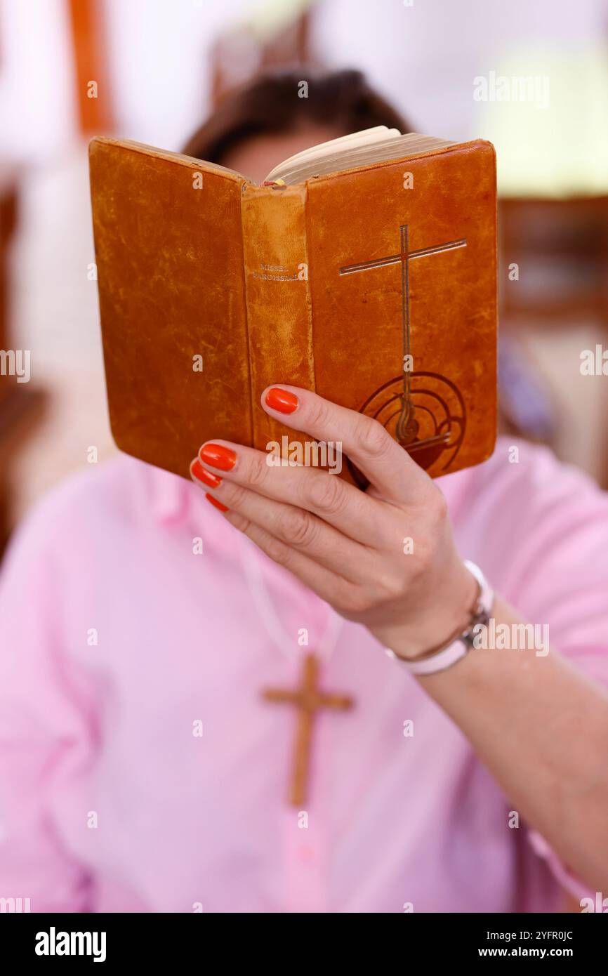 Eine Frau liest eine alte Bibel in einer Kirche. Stockfoto