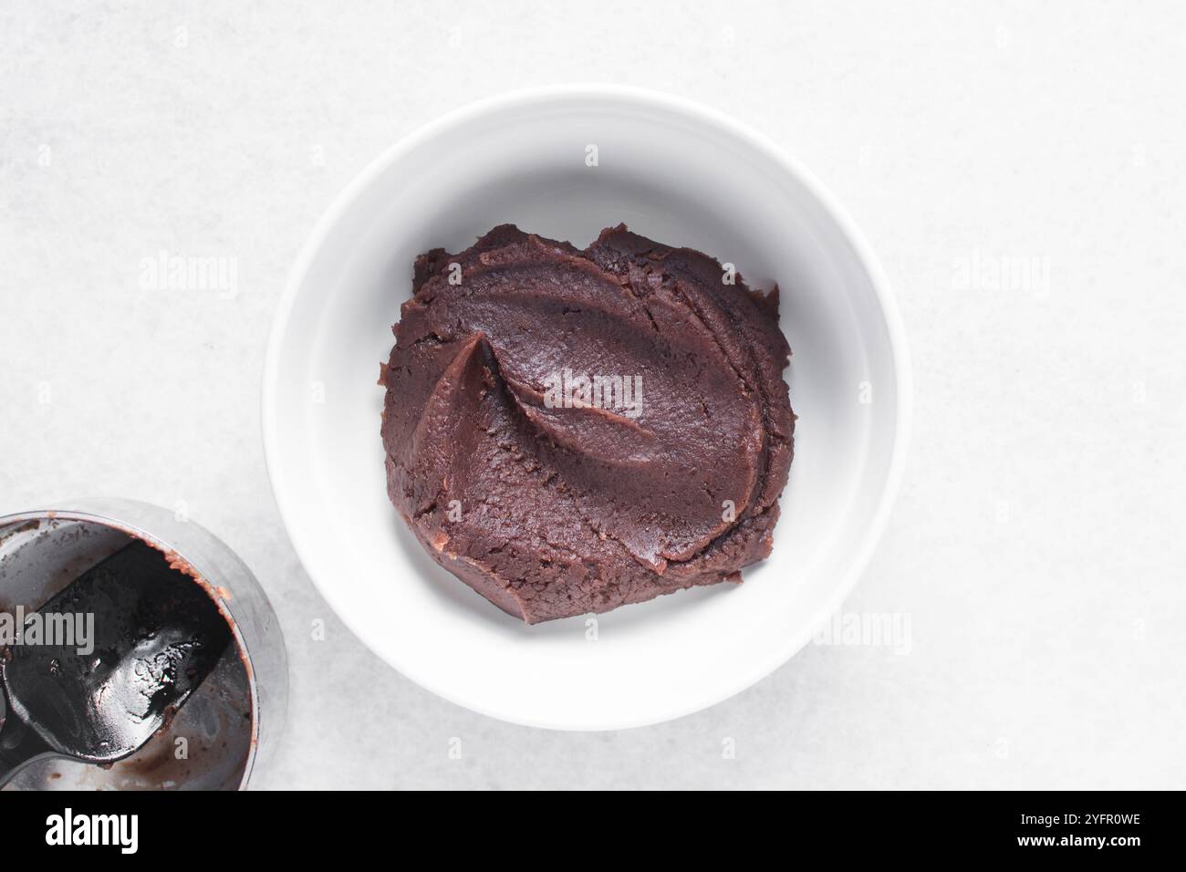 Überkopfansicht der roten Bohnenpaste in einer weißen Schüssel, Draufsicht der süßen Adzuki Bohnenpaste in einer weißen Platte, Prozess der Herstellung von Anko oder roter Bohnenpaste Stockfoto