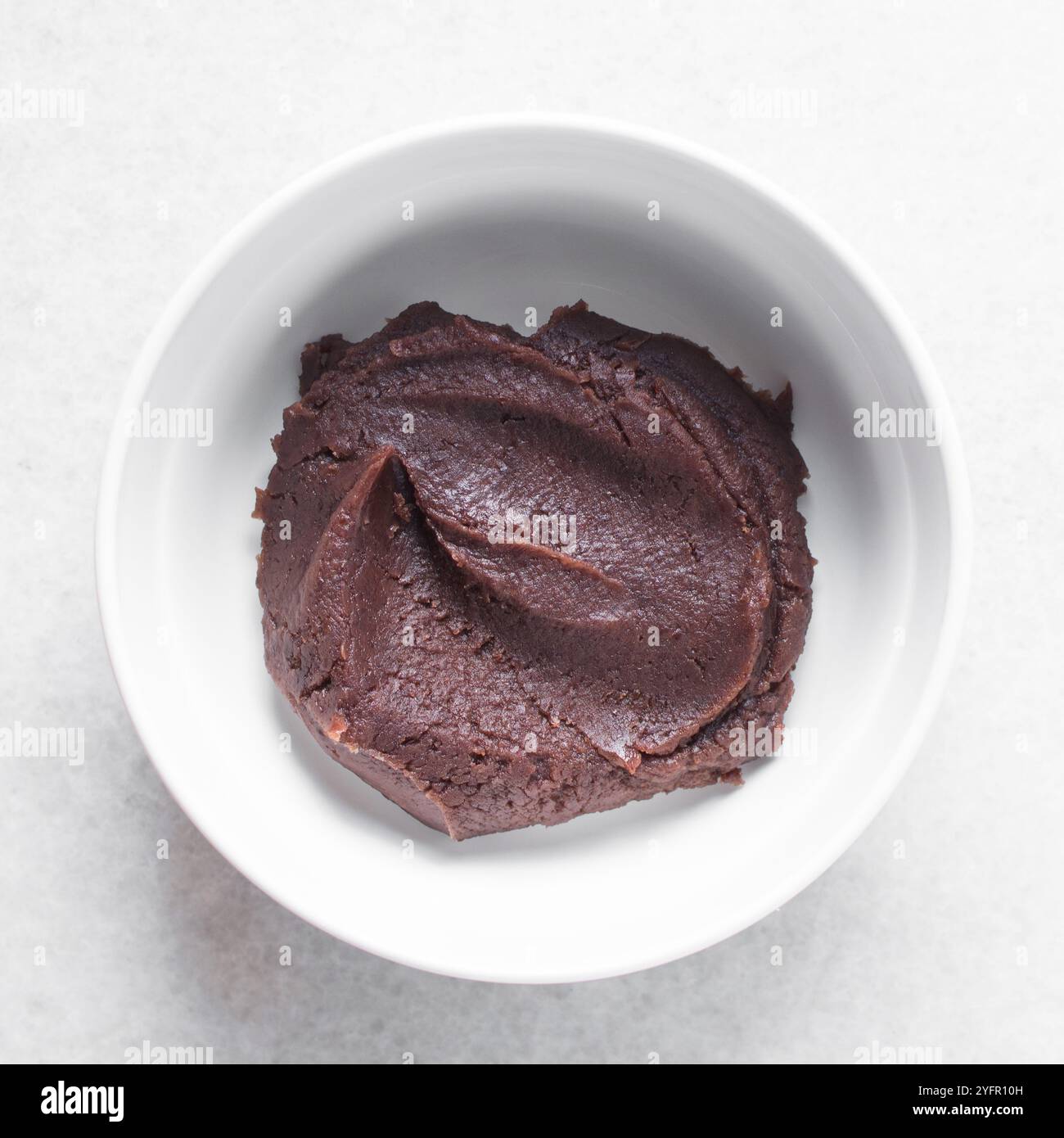 Überkopfansicht der roten Bohnenpaste in einer weißen Schüssel, Draufsicht der süßen Adzuki Bohnenpaste in einer weißen Platte, Prozess der Herstellung von Anko oder roter Bohnenpaste Stockfoto