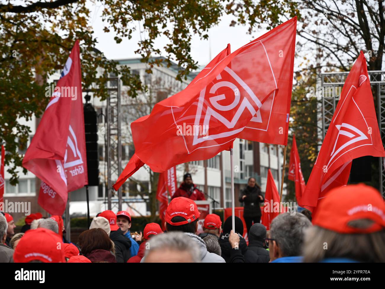 Hamburg, Deutschland. November 2024. Die Teilnehmer stehen mit Fahnen mit dem IG Metall Logo auf einer von der IG Metall Küste organisierten Rallye vor dem Werk Körber Technologies. Die gewerkschaft IG Metall Küste hat zu weiteren Warnstreiks in Hamburg und Schleswig-Holstein im Lohnstreit mit der Metall- und Elektroindustrie aufgerufen. Quelle: Niklas Graeber/dpa/Alamy Live News Stockfoto