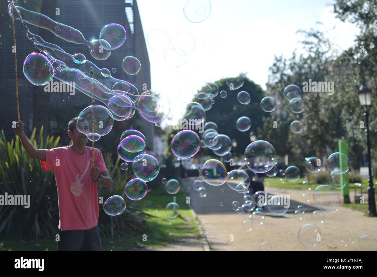 Persona haciendo burbujas de jabón en la calle Stockfoto