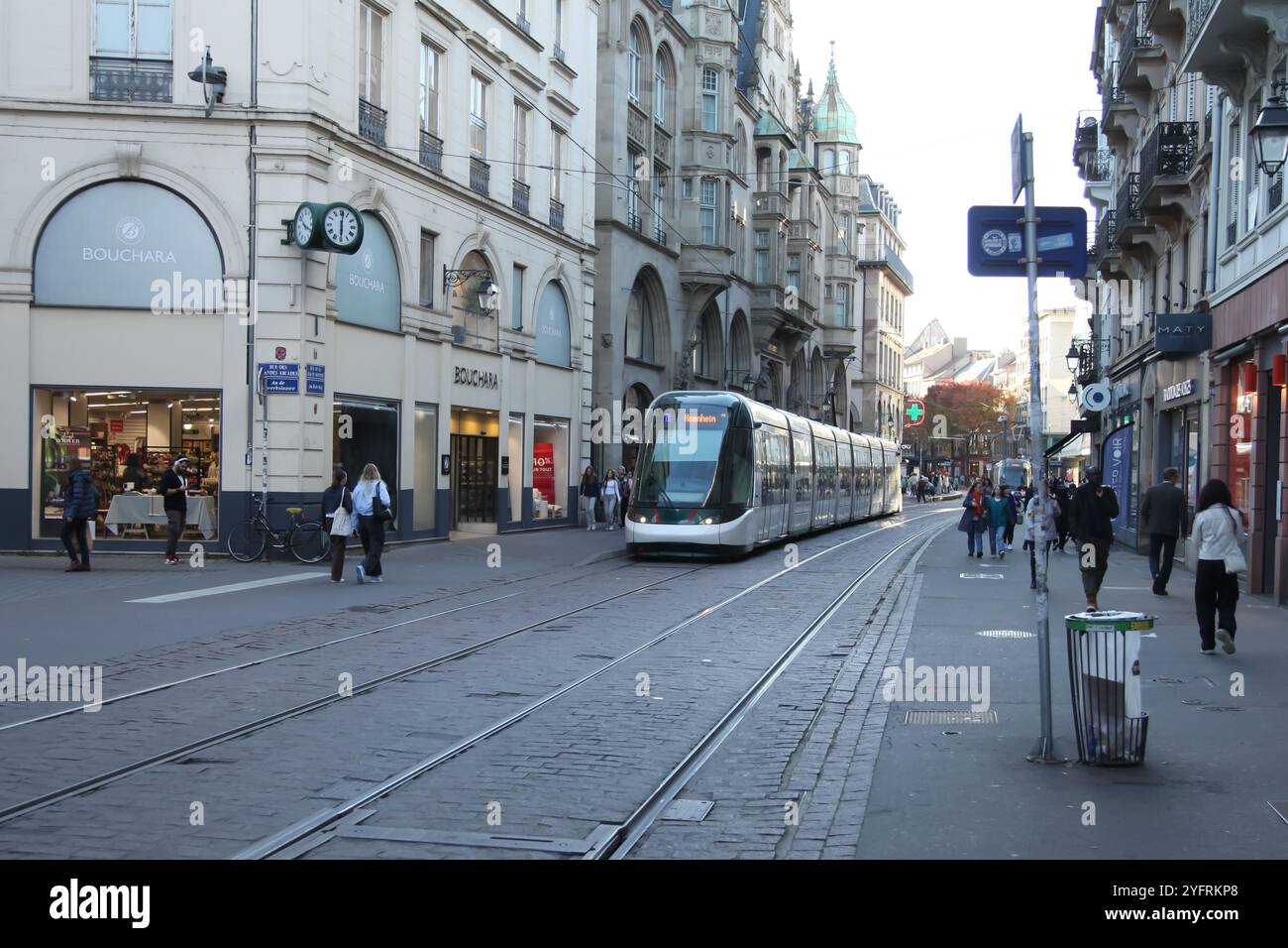 Eine Straßenbahn fährt entlang der Rue de la Mesange, einer Einkaufsstraße voller Touristen in Straßburg, Frankreich, 2024 Stockfoto