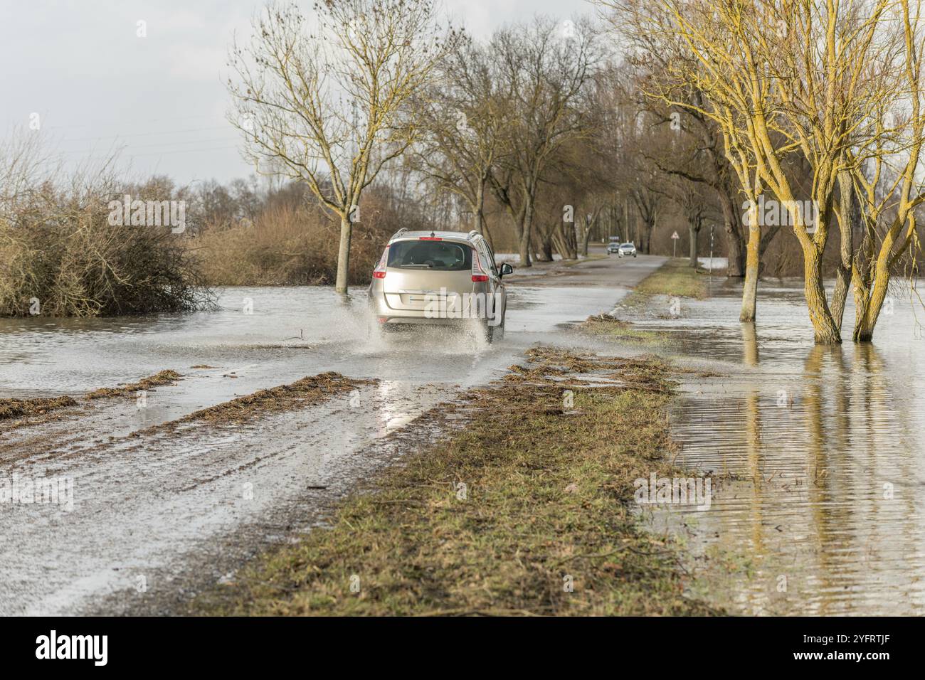 Autos, die im Winter auf einer überfluteten Straße vorbeifahren. Frankreich Stockfoto