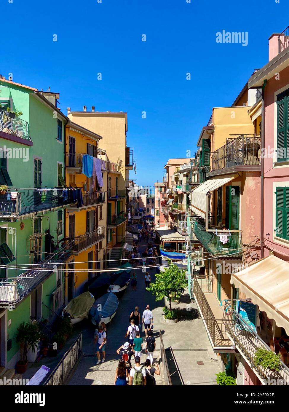 Die Hauptstraße von Manarola, Cinque Terre, Liguarische Küste, Italien, mit ihren farbenfrohen Gebäuden und einem schönen sonnigen Tag - Smartphone-aufgenommenes Stockfoto