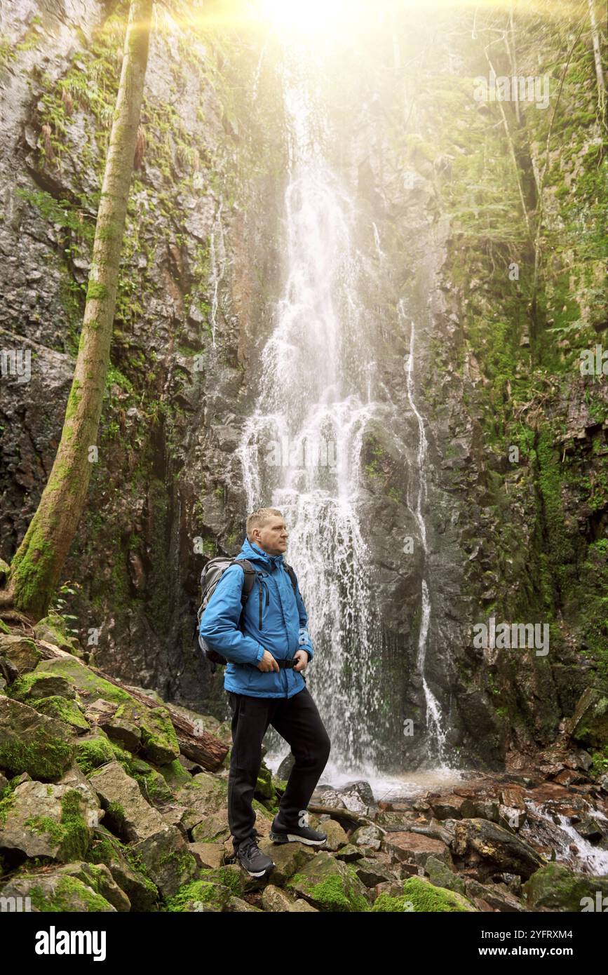 Touristenattraktion Deutschlands, Wasserfall Burgbach bei Schapbach, Schwarzwald, Baden-Württemberg, Deutschland. Mann Wanderer in blauer Jacke stehend Stockfoto