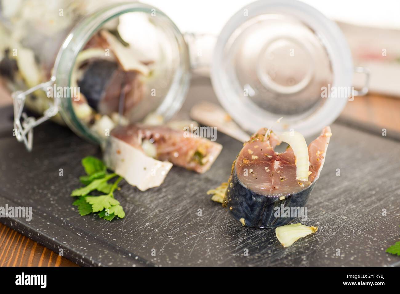 Leicht gesalzene Makrele in Stücke geschnitten mit Zwiebeln und Gewürzen. Stockfoto