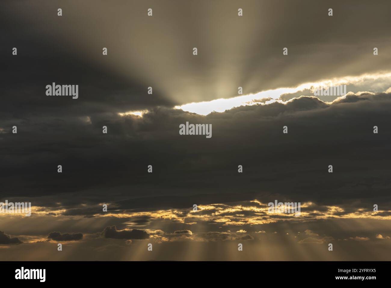 Lichtstrahlen der Sonnenstrahlen durch Wolken am Morgen. Elsass, Frankreich, Europa Stockfoto