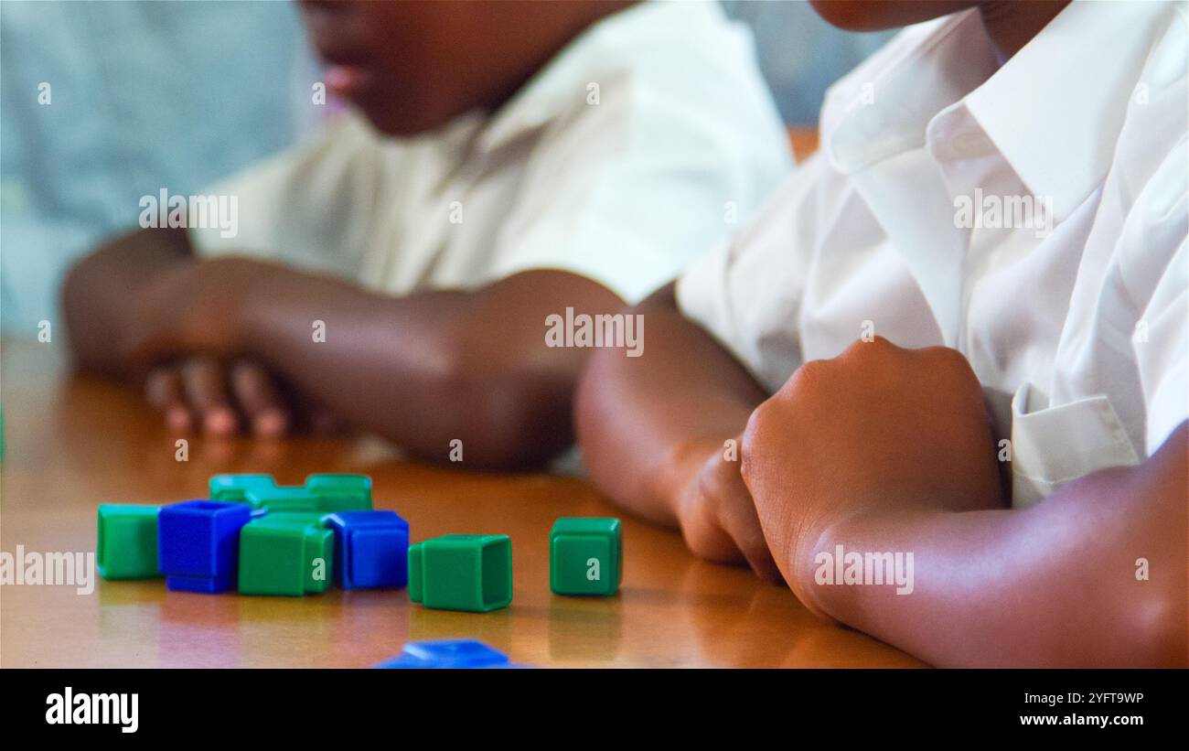 Die Schüler konzentrierten sich auf eine praktische Lernaufgabe mit farbenfrohen Blöcken. Stockfoto
