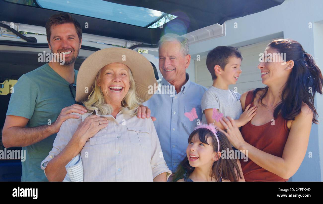 Porträt Der Familie Mehrerer Generationen, Die Das Gepäck Auf Der Rückseite Des Autos In Den Sommerurlaub Lädt Stockfoto