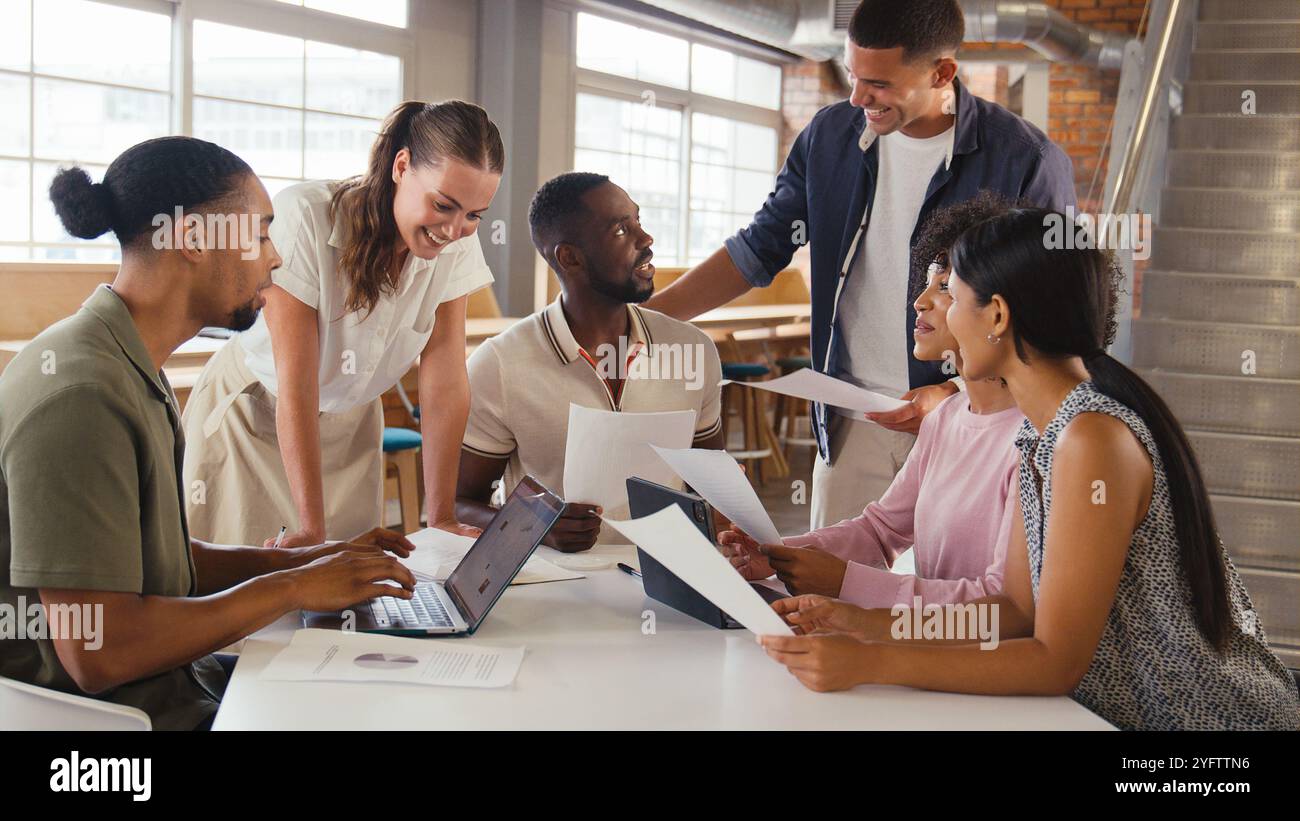Multikulturelles Business Team-Meeting Rund Um Den Schreibtisch Im Modernen Open Plan Office, Um Dokumente Zu Diskutieren Stockfoto