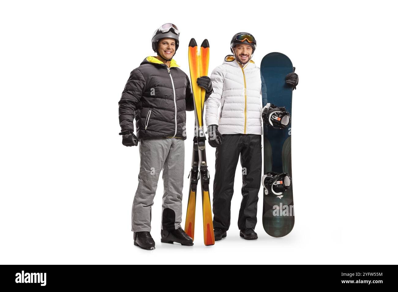 Porträt eines Mannes mit Snowboard und Skiern in voller Länge, der die Kamera isoliert auf weißem Hintergrund betrachtet Stockfoto