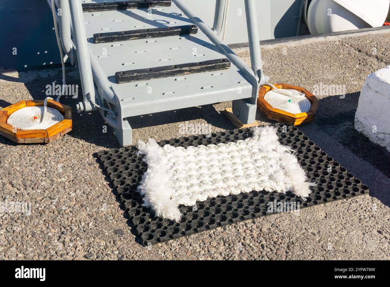 Maritime Tradition: Eine schneeweiße Türmatte aus Seilen vor der Gangway unterstreicht die Sauberkeit des Schiffsdecks Stockfoto