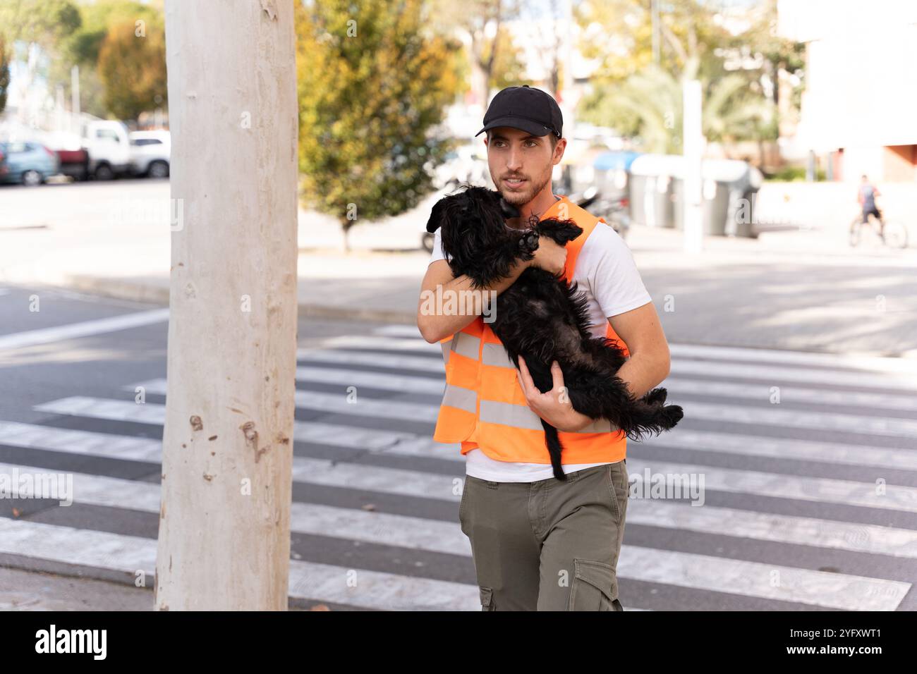 Geretteter Hund von einem Unfall, der in den Armen eines tapferen jungen Mannes lag Stockfoto