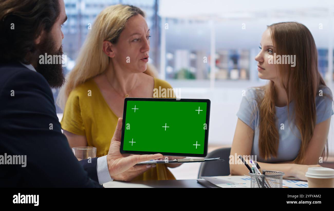 Kunden, die sich einen personalisierten Planungsleitfaden auf einem Tablet mit isoliertem Bildschirm ansehen, das von einem Finanzberater erstellt wurde. Buchhalter optimiert die Lebenskosten für Kunden mit Chroma Key Device, Kamera B Stockfoto