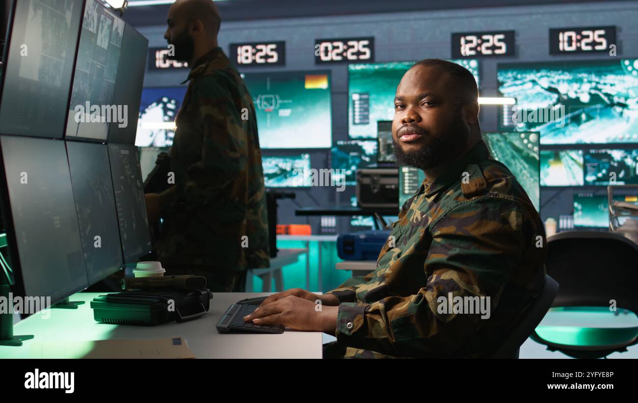 Armeeoperateur in der Kommandozentrale analysiert Überwachungsdaten während des globalen Krieges. Der Geheimdienstagent in der Basis der Operationen beendet die Mission während der geopolitischen Operation des 3. Weltkriegs, Kamera B Stockfoto