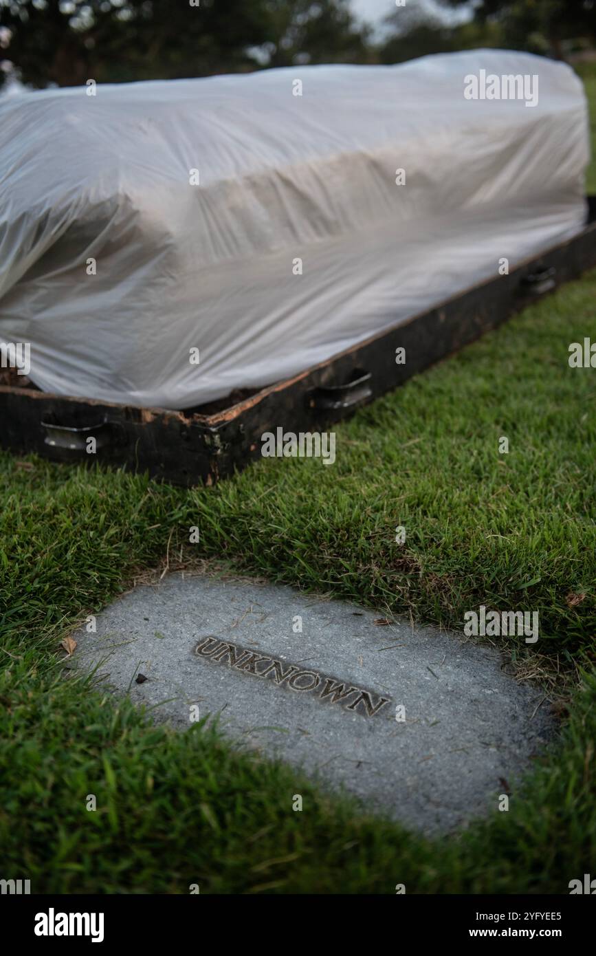 Ein Sarg befindet sich neben einem gekennzeichneten Grab eines unbekannten Soldaten während einer Zeremonie der Zeremonie auf dem National Memorial Cemetery of the Pacific, Honolulu, Hawaii, 4. November 2024. Acht Personen wurden im Rahmen des West Loch Project desintert: Ein fortlaufender Versuch der Defense POW/MIA Accounting Agency, Soldaten zu desinfizieren, zu transportieren und zu identifizieren, die während des Zweiten Weltkriegs bei der Katastrophe in West Loch ums Leben kamen. 132 bestätigte Soldaten wurden getötet oder verwundet, während sie Munition und Treibstoff auf Schiffe auf der West Loch Halbinsel in Pearl Harbor verladen. In diesem Jahr feierte der 80. Jahrestag von Stockfoto