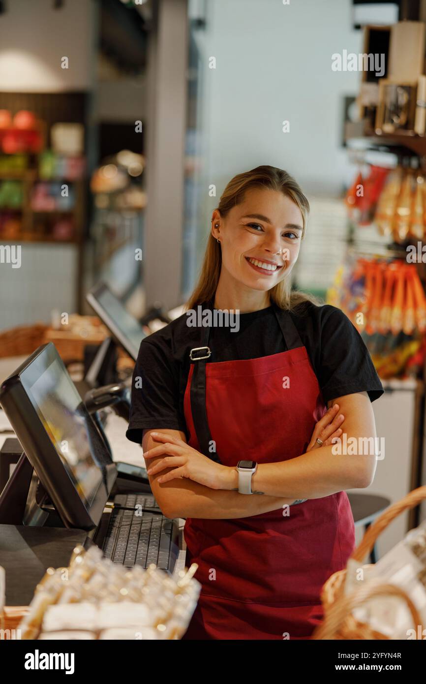 Fröhlicher Barista, der in einer gemütlichen Caf-Umgebung lächelt Stockfoto