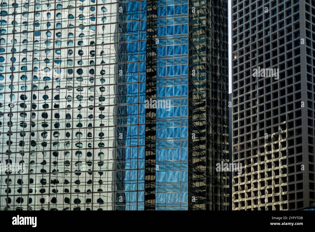 Das Jardine House-Gebäude im Central District von Hong Kong spiegelt sich in einem weiteren Wolkenkratzer wieder Stockfoto