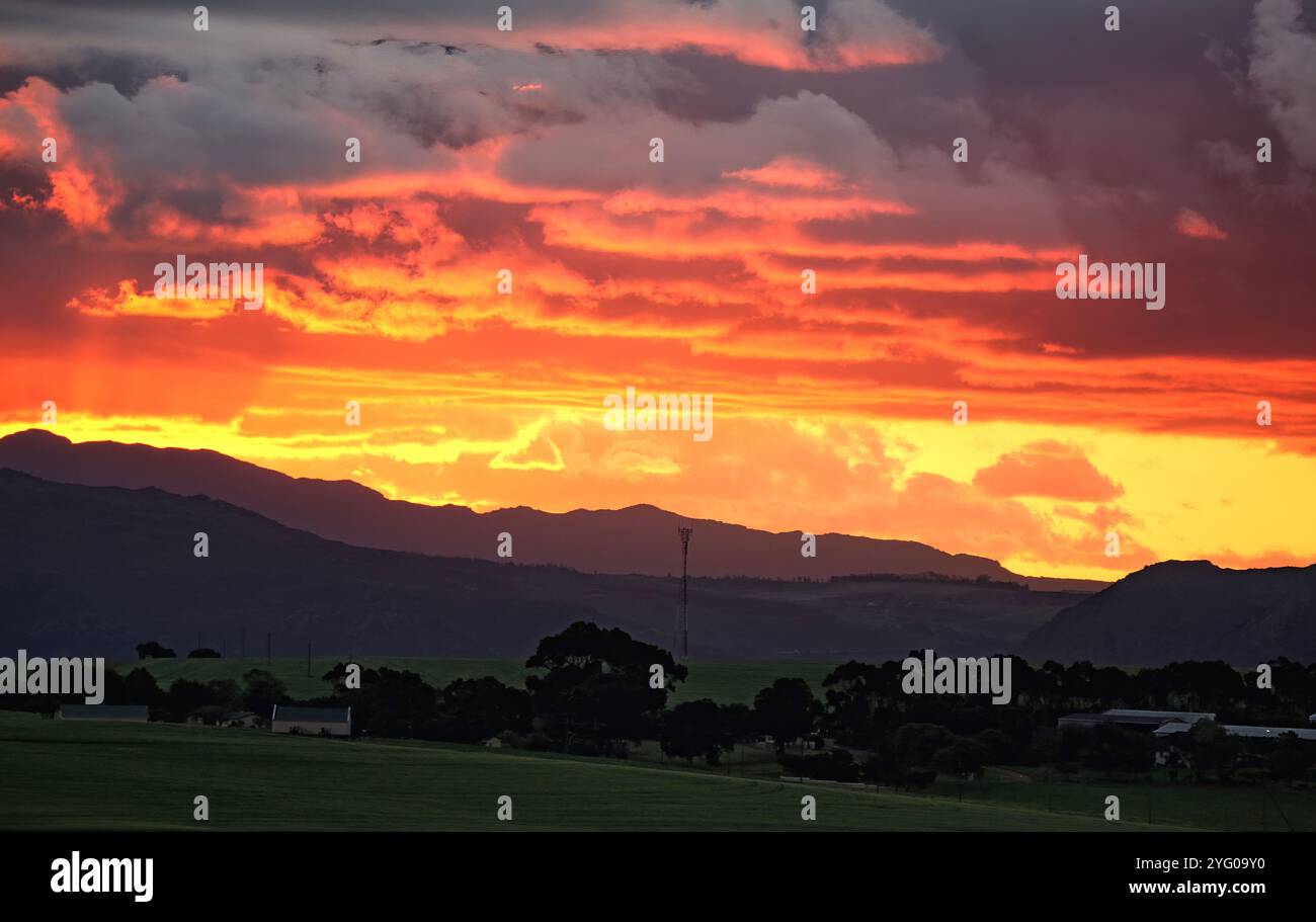 Sonnenuntergang über den Hottentots-Holland-Bergen und den Feldern der Landwirtschaft im Overberg, Westkap. Stockfoto
