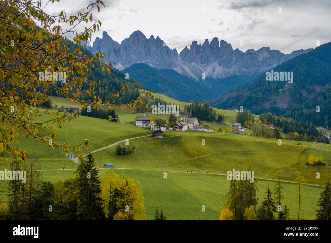 Sanfte grüne Hügel verschmelzen in die majestätischen Dolomiten und bilden eine atemberaubende Kulisse. Malerische Dörfer säumen die Landschaft, Santa Maddalena Val di Fun Stockfoto