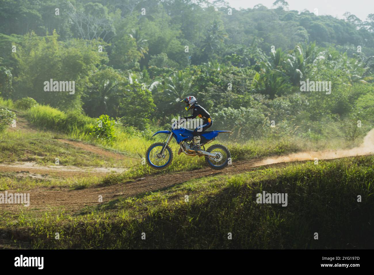 Balikpapan, Indonesien - 7. September 2024. Der Motocross-Fahrer springt auf einer staubigen Strecke unter der heißen Sonne Stockfoto