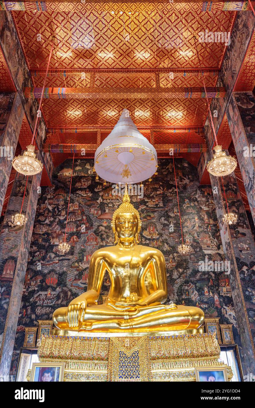 Fantastischer Blick auf die vergoldete Buddha-Statue zwischen erstaunlichen Wandmalereien Stockfoto