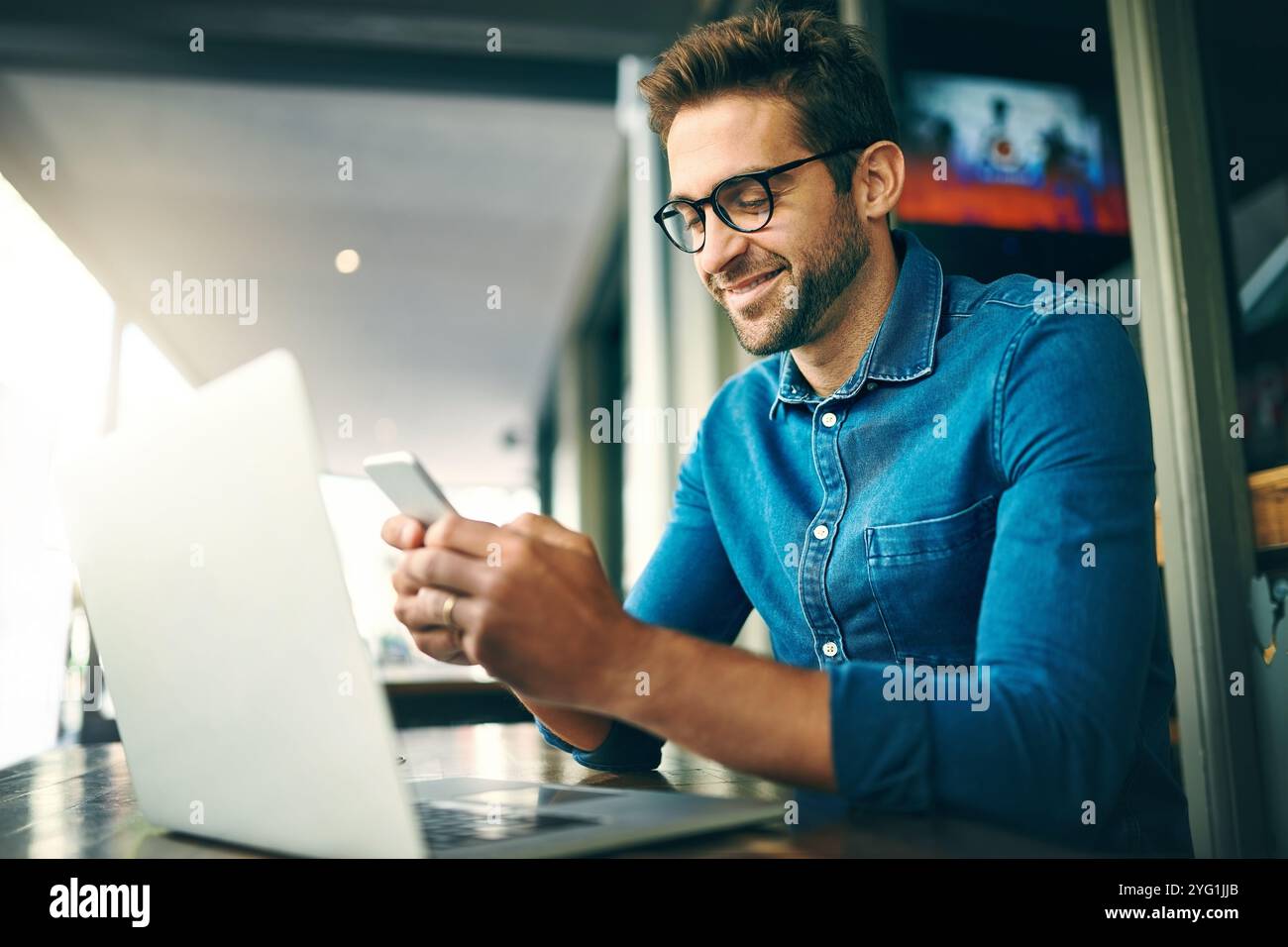 Geschäftsmann, Telefon und Laptop für Netzwerke, Forschung und Projektmanagement mit kpi-App im Büro. Mitarbeiter, glücklich und mobil am Arbeitsplatz für Stockfoto